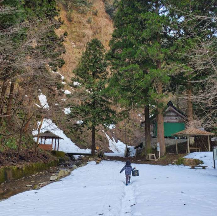 雪の積もった道を歩く子どもの後ろ姿