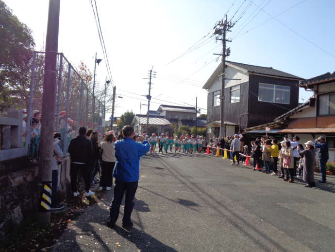 持久走大会をする小学生と、応援する地域の大人